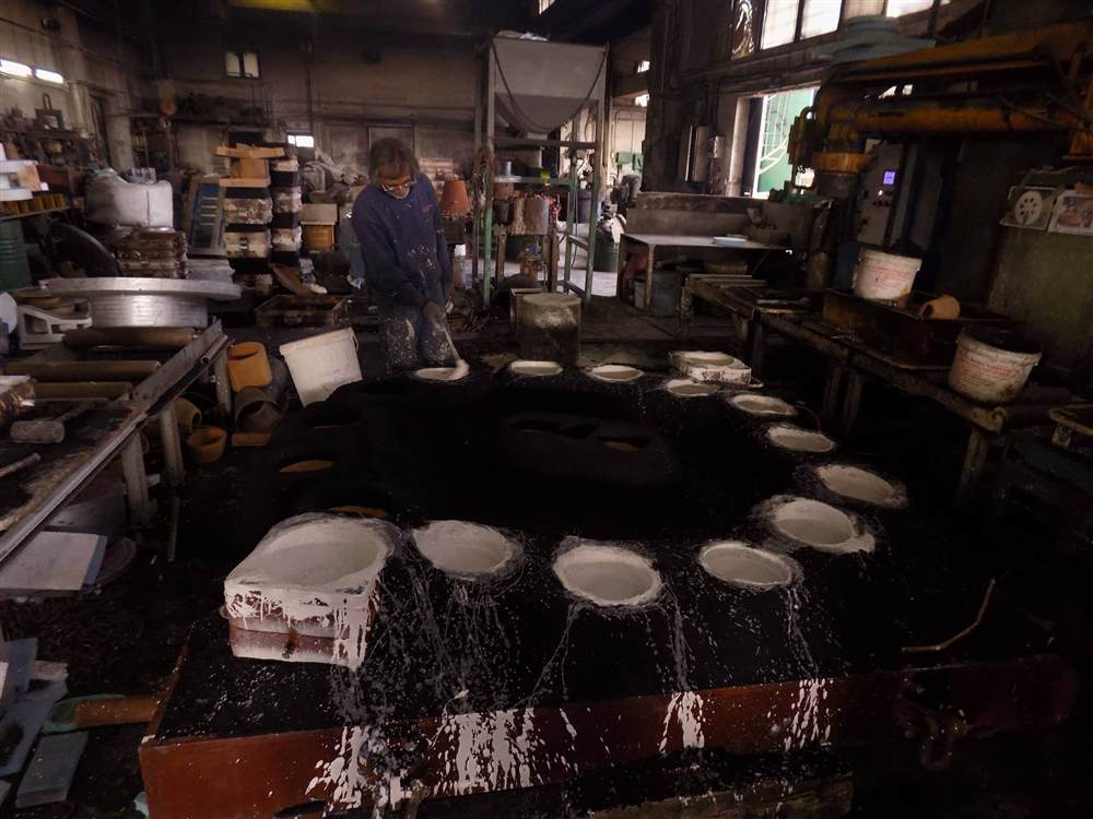 Coating the closed sand mould with refractory wash before pouring